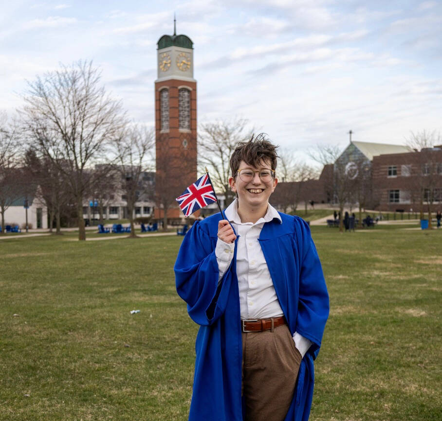 Grad photo of Remus in front of the clocktower with a UK flag